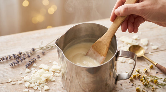 Cire de soja crème fondue mélangée à la spatule en bois dans un pichet, atelier de fabrication de bougies artisanales Aromeva